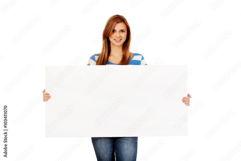 Happy teenage woman with blank billboard Happy teenage woman with blank billboard