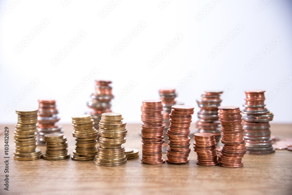 A wooden doll man with his savings, gold coin. All composed with thai baht twenty-five cent, fifty cent, thai baht and yuan A wooden doll man with his savings, gold coin. All composed with thai baht twenty-five cent, fifty cent, thai baht and yuan