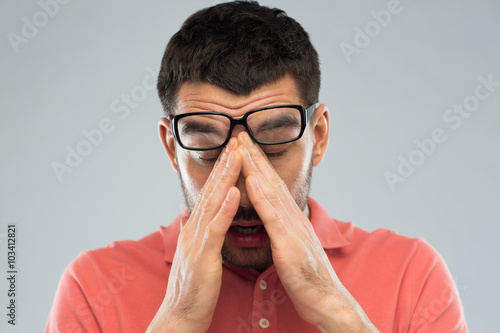 Fototapeta Naklejka Na Ścianę i Meble -  tired man in eyeglasses rubbing eyes