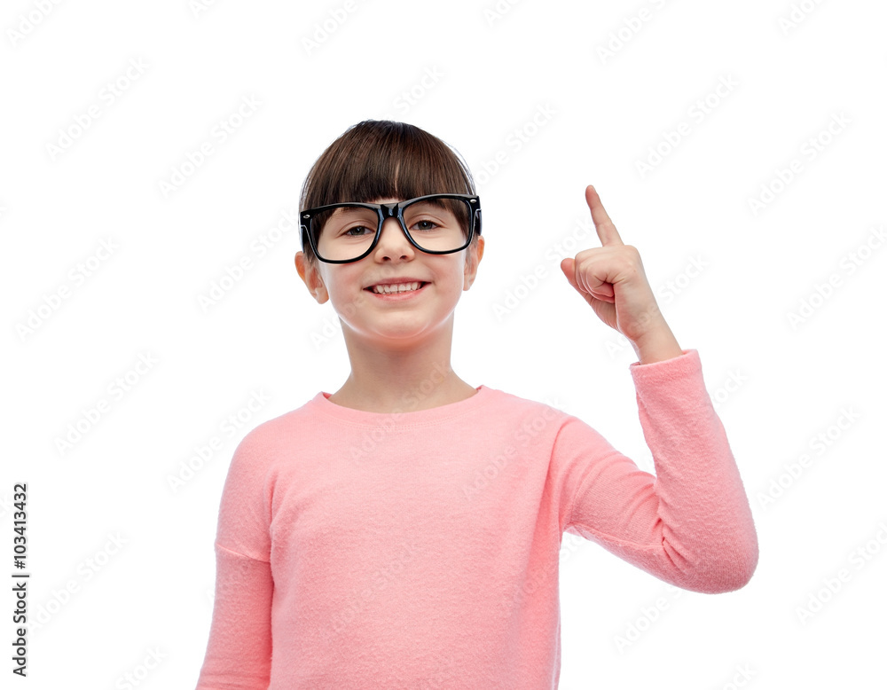 happy little girl in eyeglasses pointing finger up
