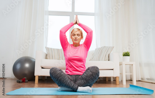 happy woman stretching leg on mat at home photo