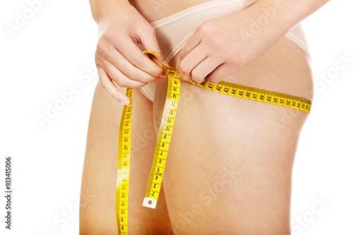 Female buttocks with a measurement tape