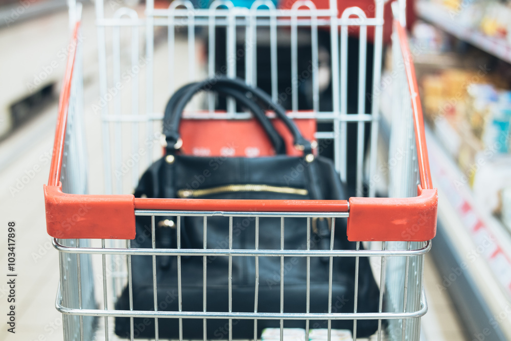 Women's bag in the trolley in a supermarket