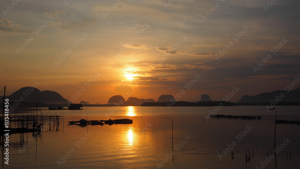 Obraz premium Landscape of nature sunrise/ sunset in the sea at Samchong fishing village in Phang-Nga, Thailand