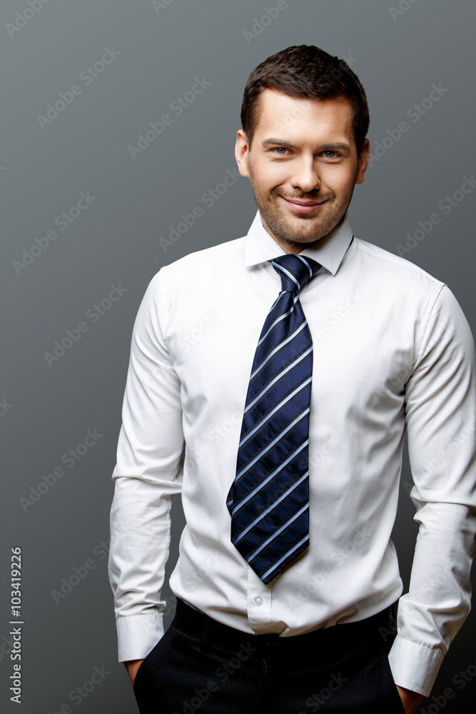Handsome stylish businessman on grey background Handsome stylish businessman on grey background