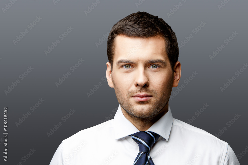 Handsome stylish businessman on grey background Handsome stylish businessman on grey background