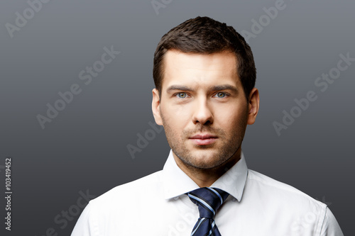 Handsome stylish businessman on grey background