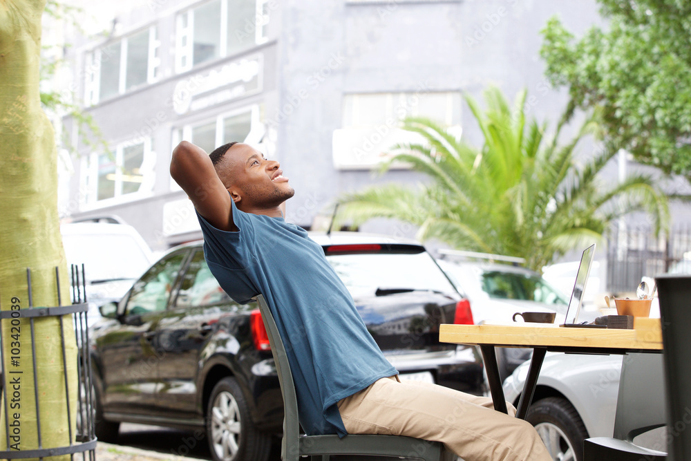 Relaxed young african man sitting at outdoor cafe Relaxed young african man sitting at outdoor cafe