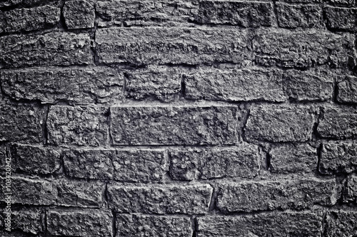 Stone wall with brick. Black-and-white image into a depression, the anger. Changes of contrast. Vignetting. Apply light and color effects to create the dramatic atmosphere of the picture.
