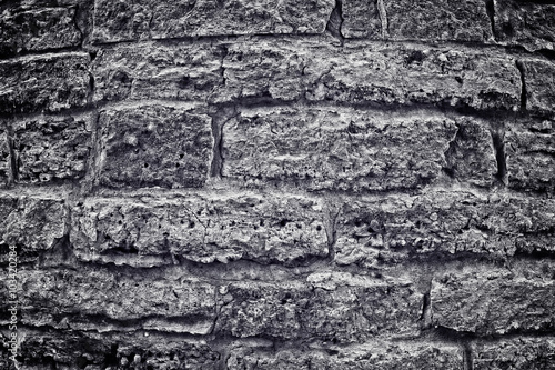 Stone wall with brick. Black-and-white image into a depression, the anger. Changes of contrast. Vignetting. Apply light and color effects to create the dramatic atmosphere of the picture.
