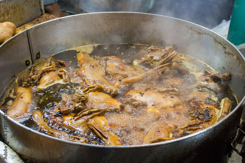 Duck stewed with gravy in big stainless pot Duck stewed with gravy in big stainless pot