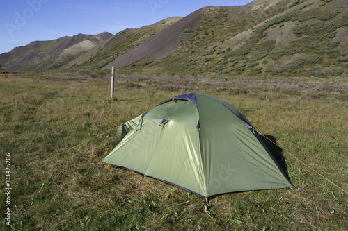 Light green tent at the foot of the mountains. Moma Mountains. Yakutia. Russia.