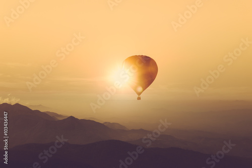 Silhouette of hot air balloon over mountain vintage color