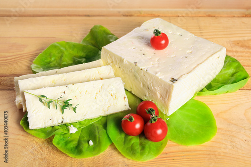 Fresh solid cream cheese on board with fresh herbs
