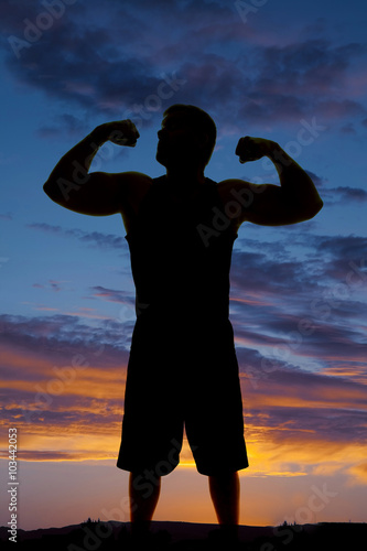 silhouette of man in tank top flex both arms