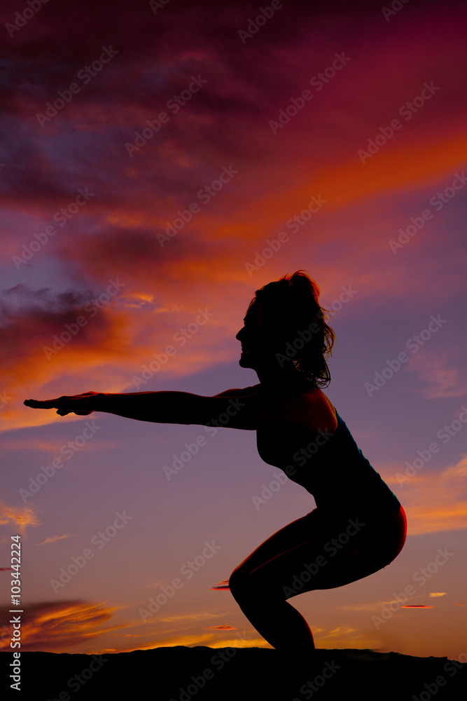 silhouette of a woman from side doing squat with arms in front