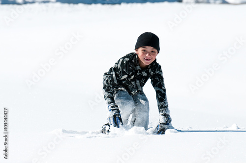 Cute boy playing in the snow.