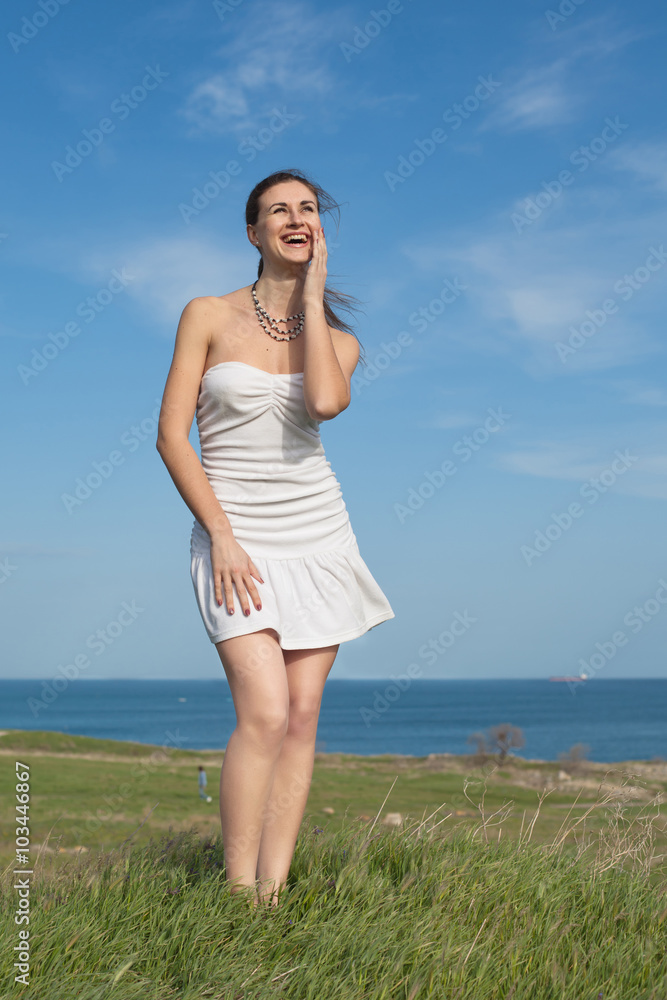 Attractive young woman in white dress laughing on background of Attractive young woman in white dress laughing on background of
