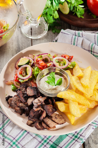 Grilled meat with French fries and fresh vegetables