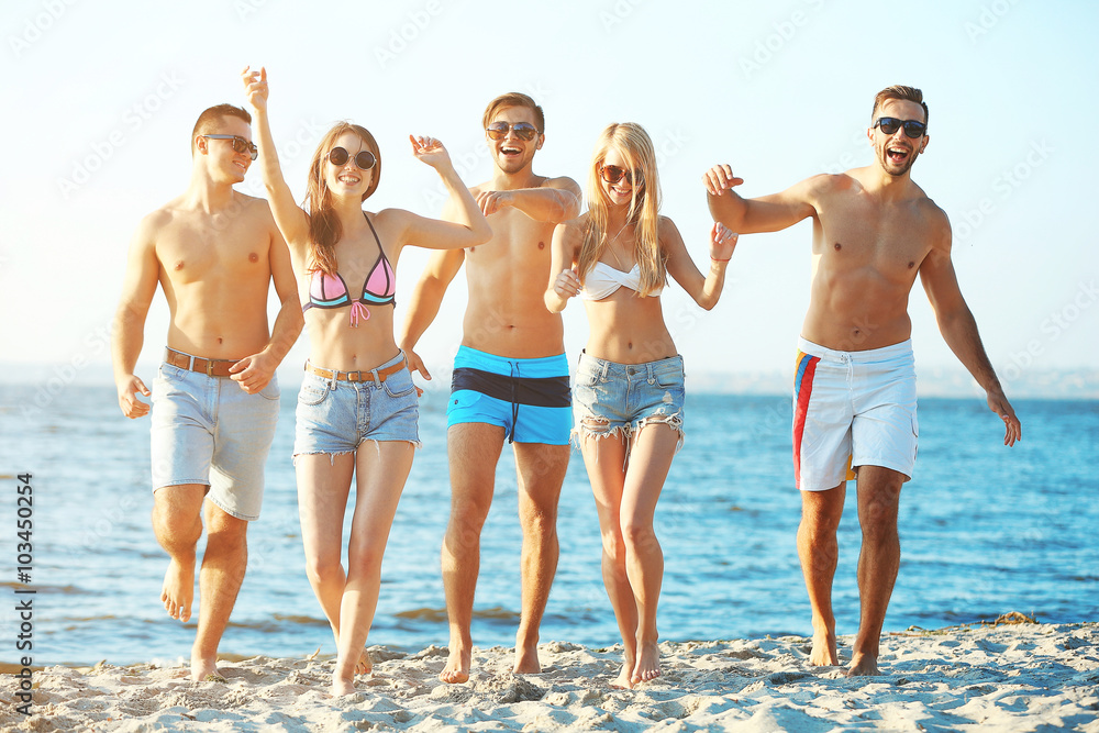 Happy friends running at the beach, outdoors Happy friends running at the beach, outdoors