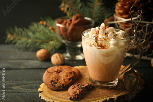 Cup of hot cacao with marshmallow and cookies on black table