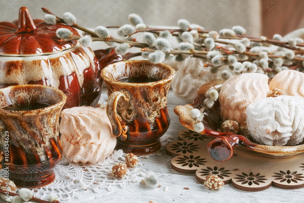 Naklejka premium cups of coffee with a pussy willow, candies and a zephyr