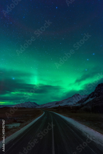 Night road in Iceland with amazing green northern lights © GavranBoris