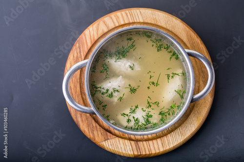 Chicken bouillon with vegetables and spices in a metal pot