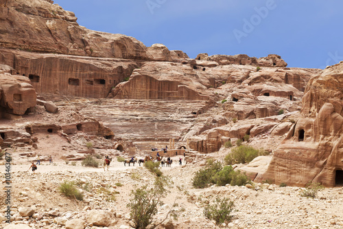 Tourists near the roman-era amphitheater carved into the pink sandstone at Petra  Jordan.