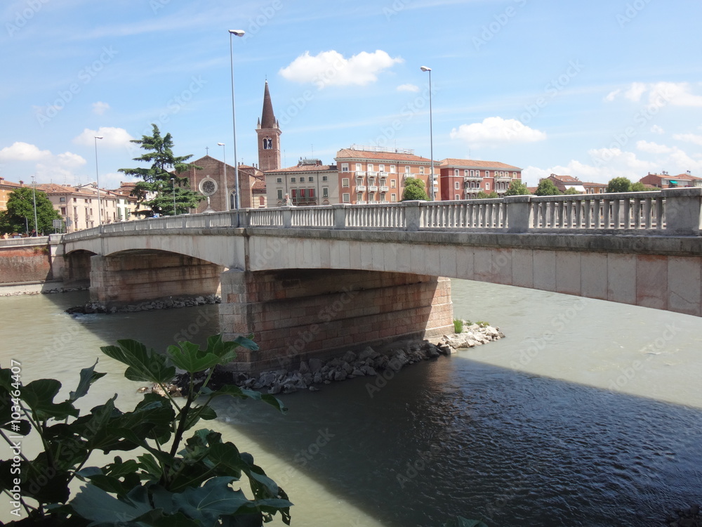 Мост через реку с мутной водой летним солнечным днем