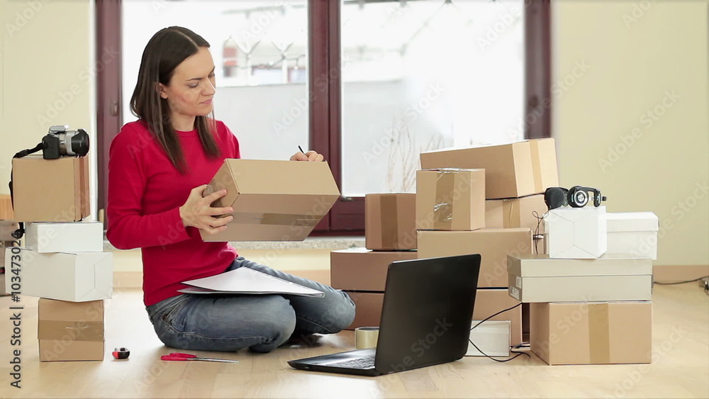 Woman labeling parcel for dispatch Woman labeling parcel for dispatch