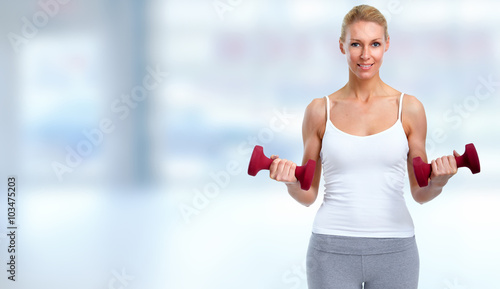 Young woman with dumbbells.