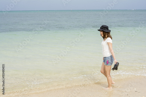 沖縄県恩納村の海辺に横向きで立つ女性