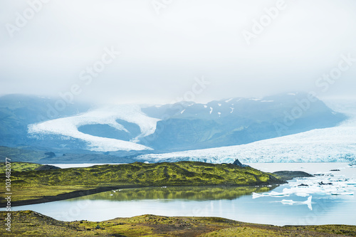 Icebergs in the glacial lake with mountain views © smallredgirl