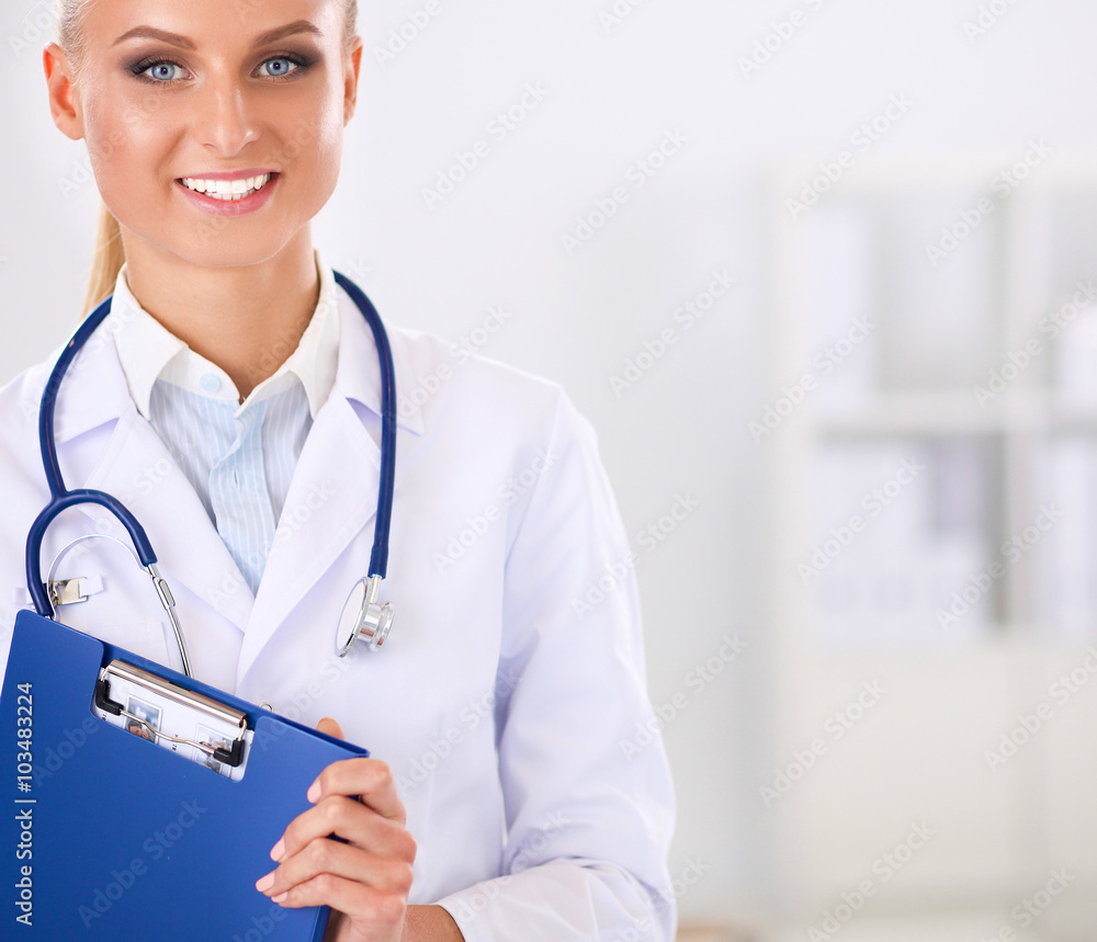 Smiling female doctor with a folder in uniform standing at hospital Smiling female doctor with a folder in uniform standing at hospital