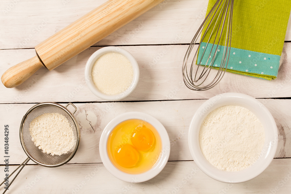 Baking in rustic kitchen recipe ingredients (milk, butter, sugar) on white wooden table from above. Baking in rustic kitchen recipe ingredients (milk, butter, sugar) on white wooden table from above.
