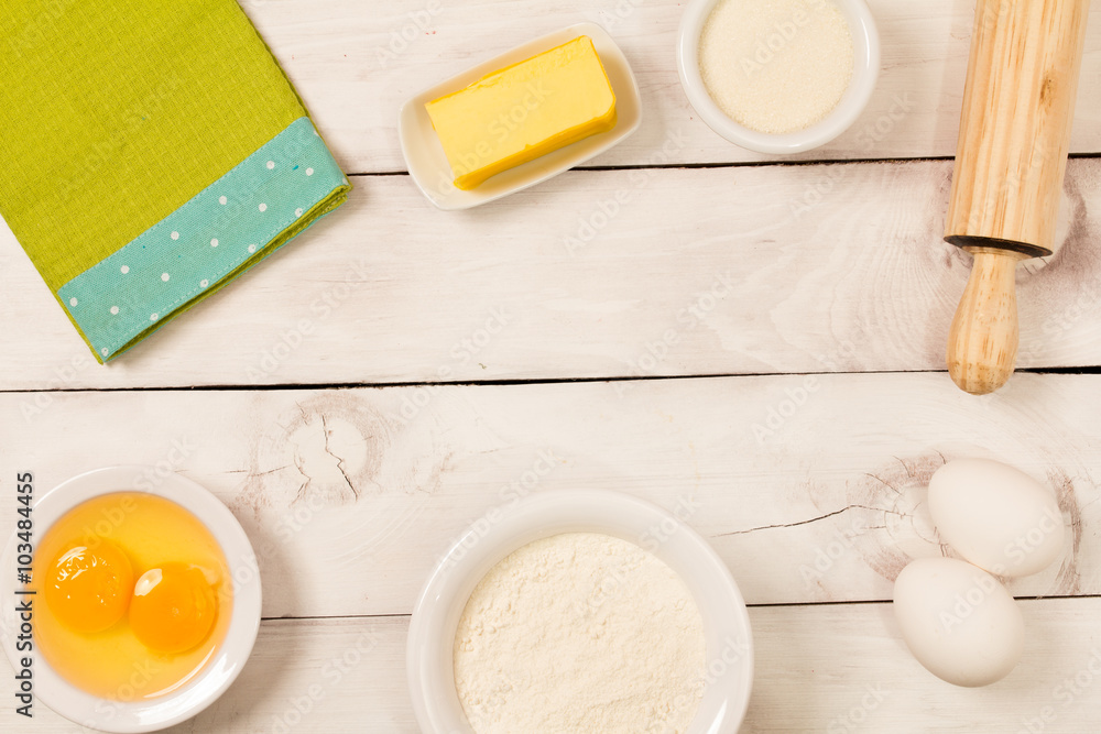 Baking in rustic kitchen ingredients (eggs, flour, milk, butter, sugar) on white wooden table from above. Baking in rustic kitchen ingredients (eggs, flour, milk, butter, sugar) on white wooden table from above.