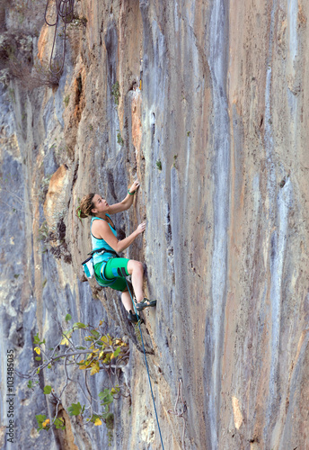 Extreme Sport Athlete hanging on vertical natural Wall