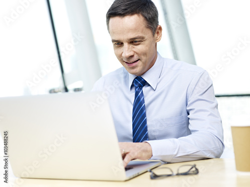 Business executive working in office with laptop