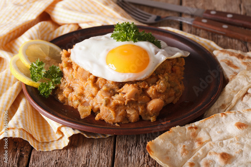 Arabic ful medames with fried eggs close-up on the table. horizontal