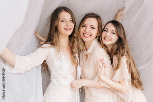 Three attractive girlfriends spends  time together at home