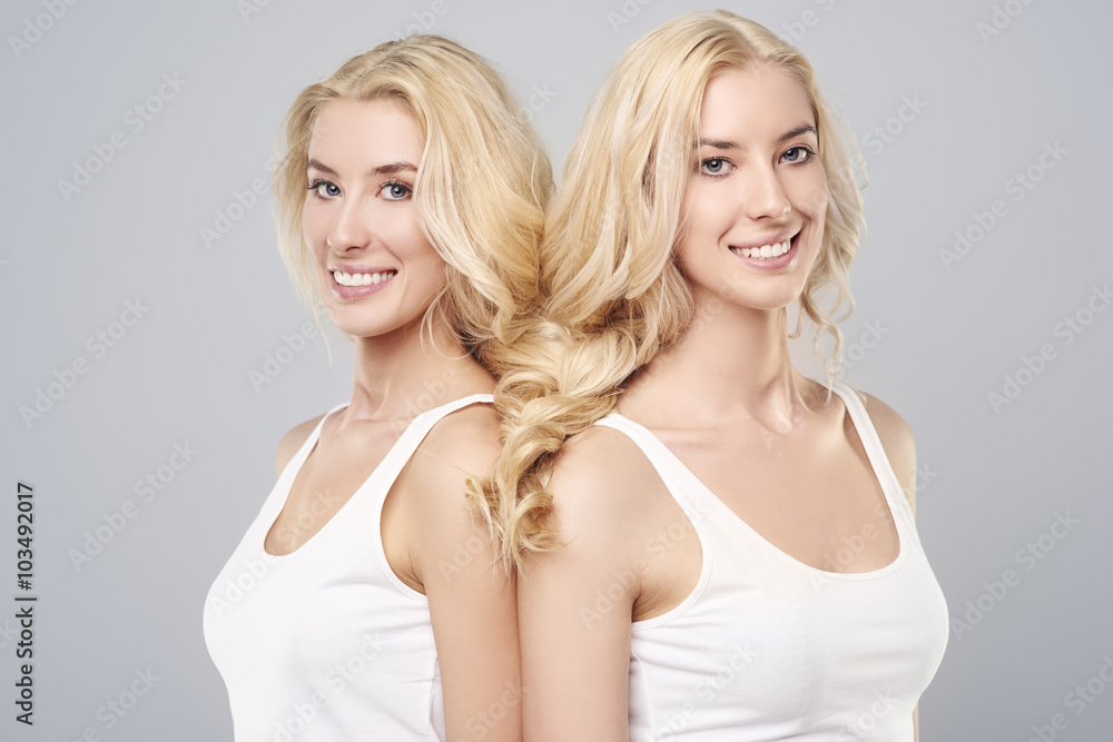 Two beautiful sisters have one braid . Two beautiful sisters have one braid .