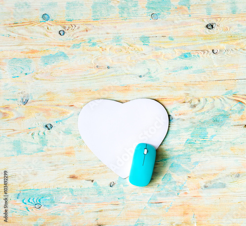 heart shaped pad with mouse on wooden background