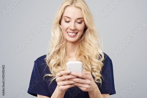 Blonde woman with white smartphone