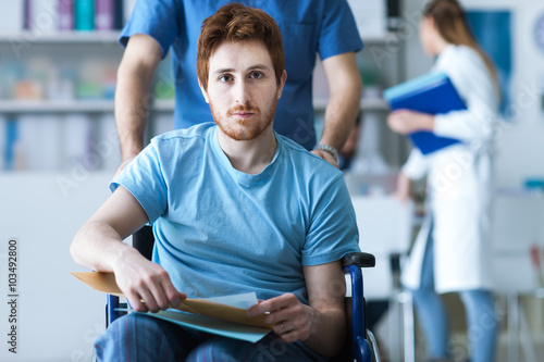 Healthcare worker pushing a man in wheelchair