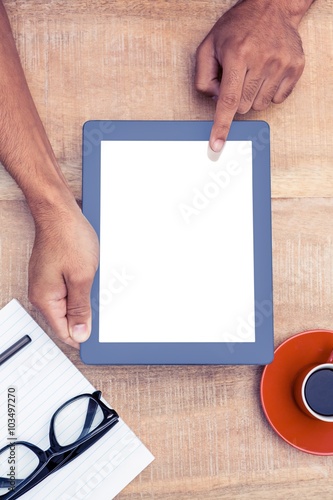 Overhead view of person using on digital tablet by coffee and document on table