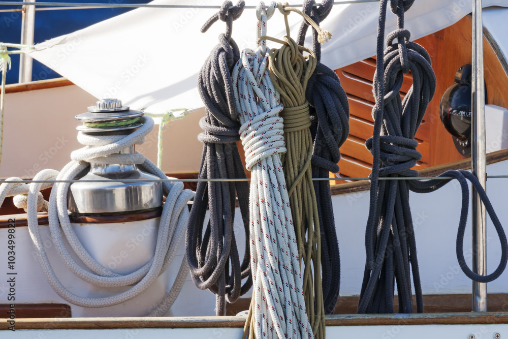 Ropes winch and nautical knots with accessories on a white fiberglass sailboat - obrazy, fototapety, plakaty 