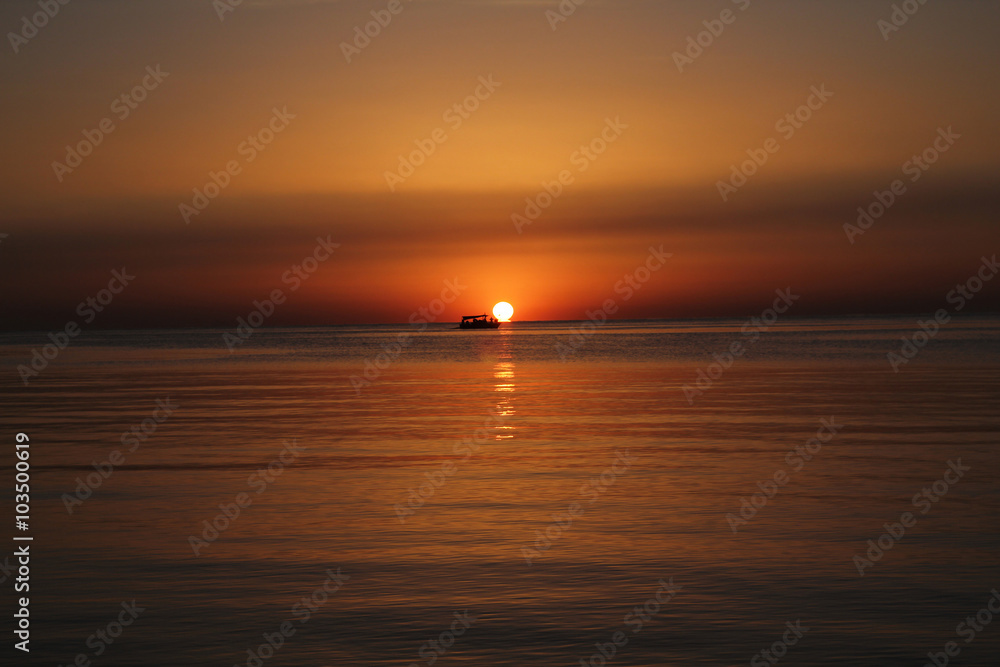 Sunrise over sea with boat
