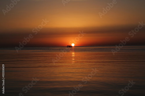 Sunrise over sea with boat © vzmaze