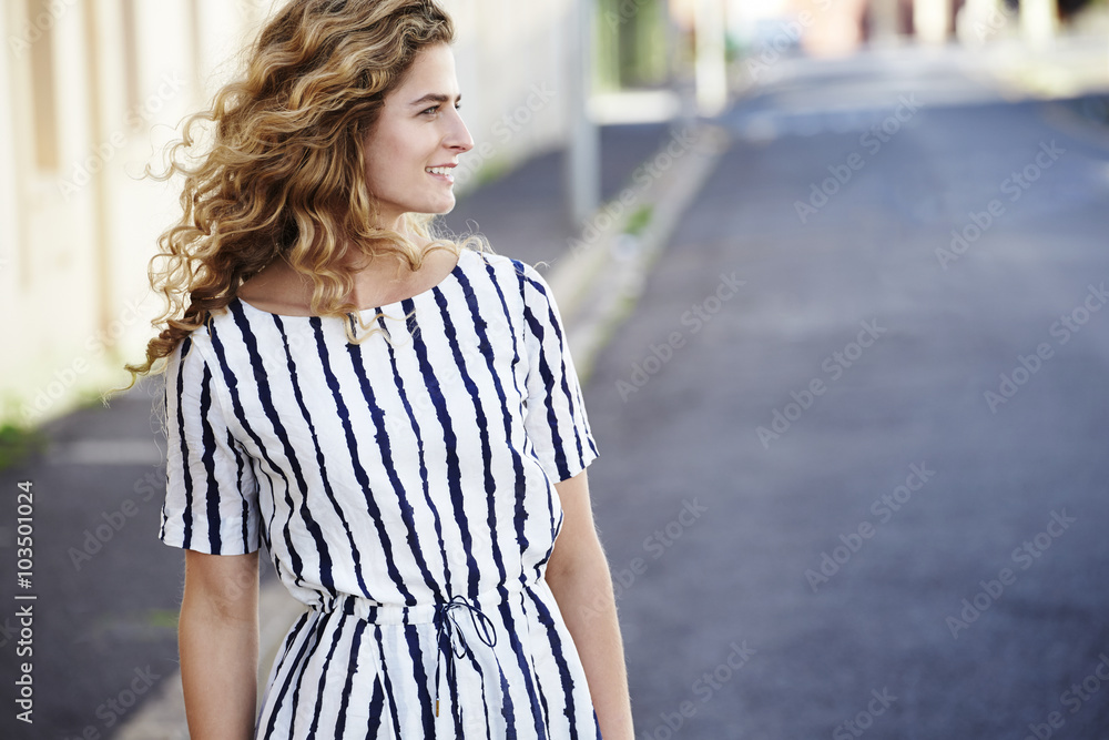 Smiling young woman in striped dress, profile